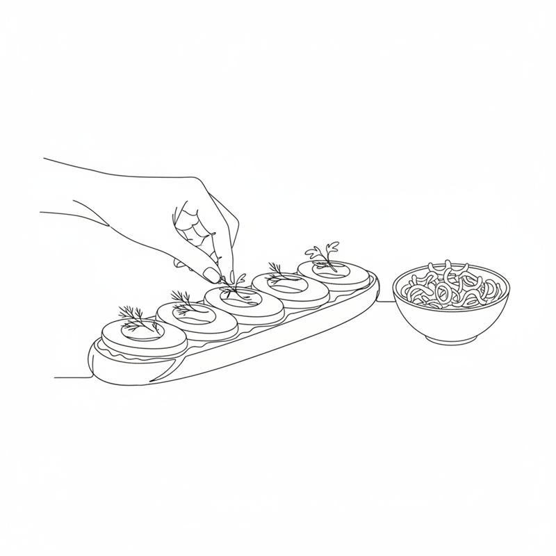 Unos dedos colocan ramitas pequeñas de eneldo sobre rodajas redondas de huevo y tomate en un pan largo; al lado hay un cuenco con cebolla frita crujiente