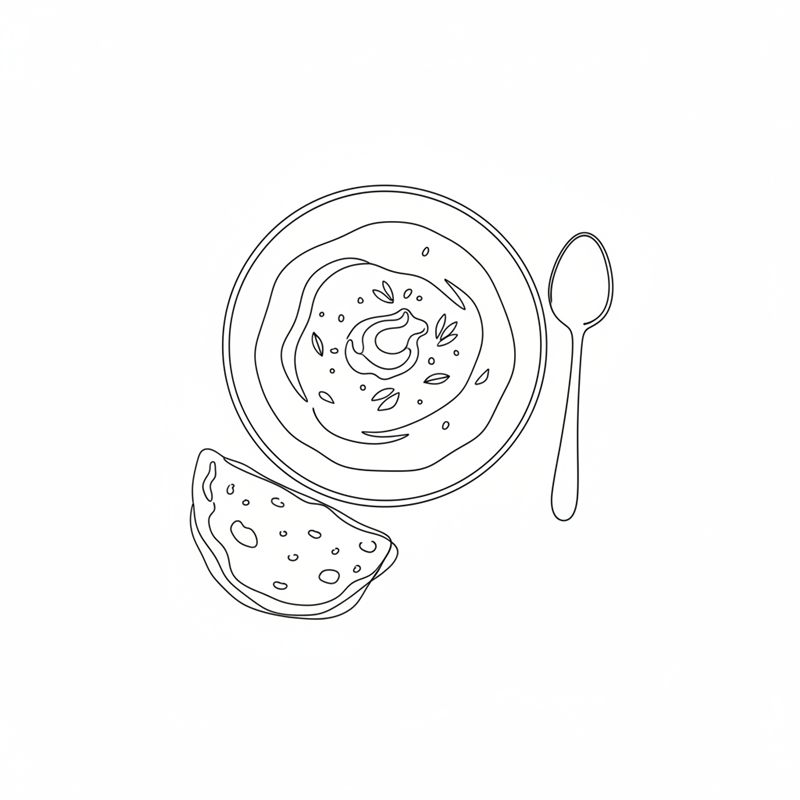 Un bol de garbanzos al curry visto un poco desde arriba, con una cucharada de crème fraîche y un par de hojas encima; al lado, una cuchara y un trozo de pan plano.